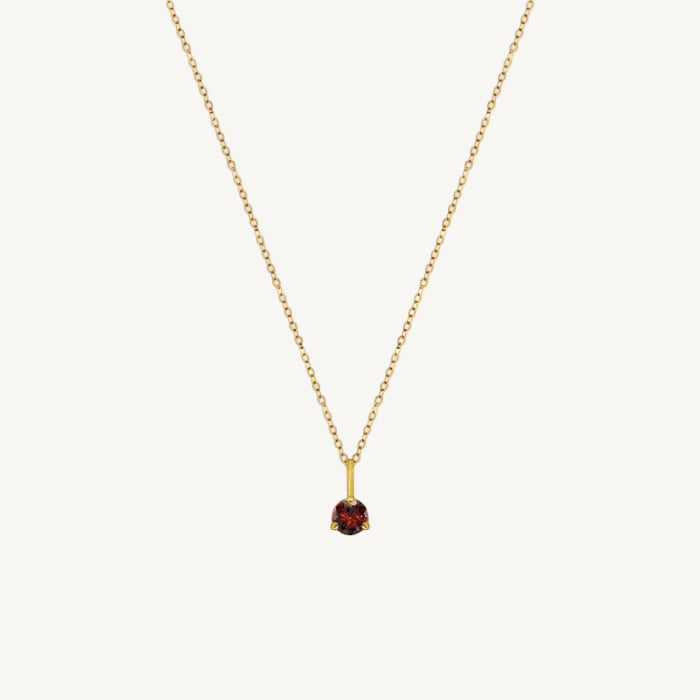 Gold necklace with a garnet gemstone pendant on a white background
