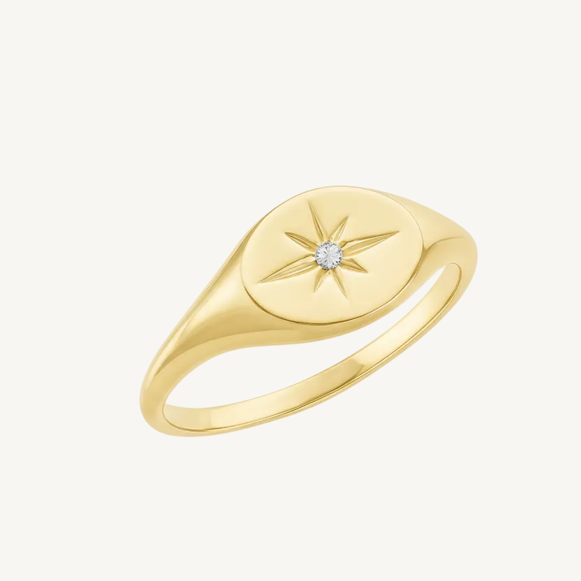 Gold ring with star design and diamond on a white background
