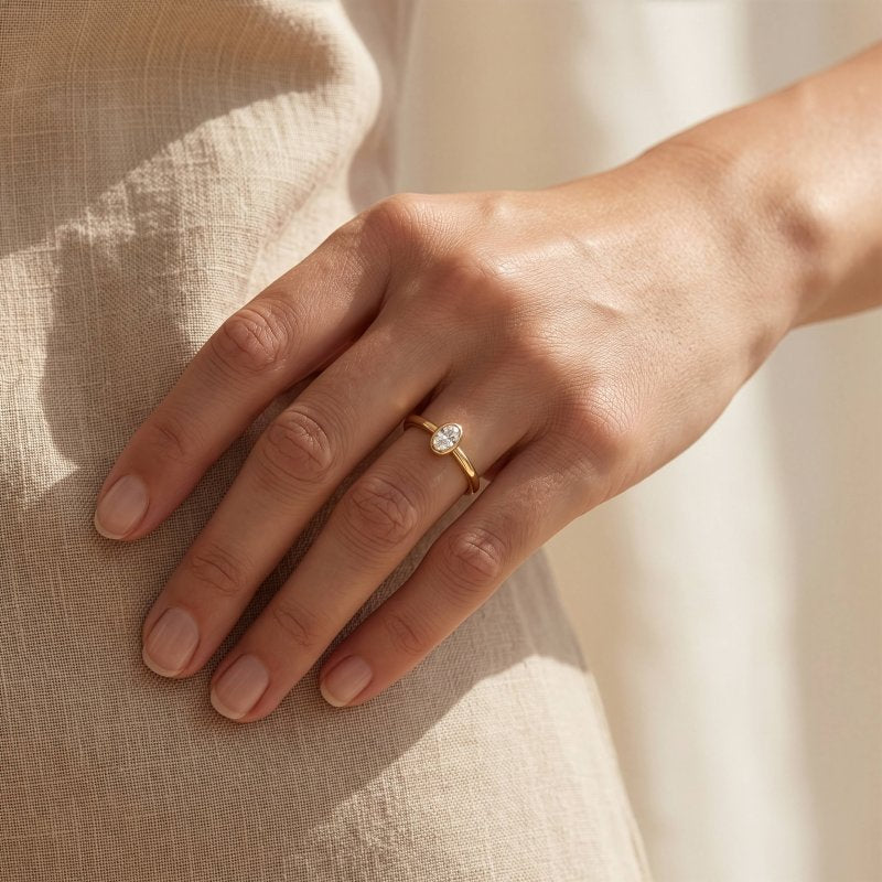 Model wearing the Elle oval lab diamond bezel solitaire ring in gold vermeil.