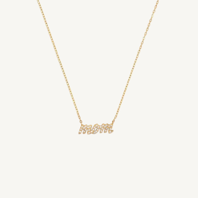 Gold necklace with diamond 'MOM' pendant on a white background