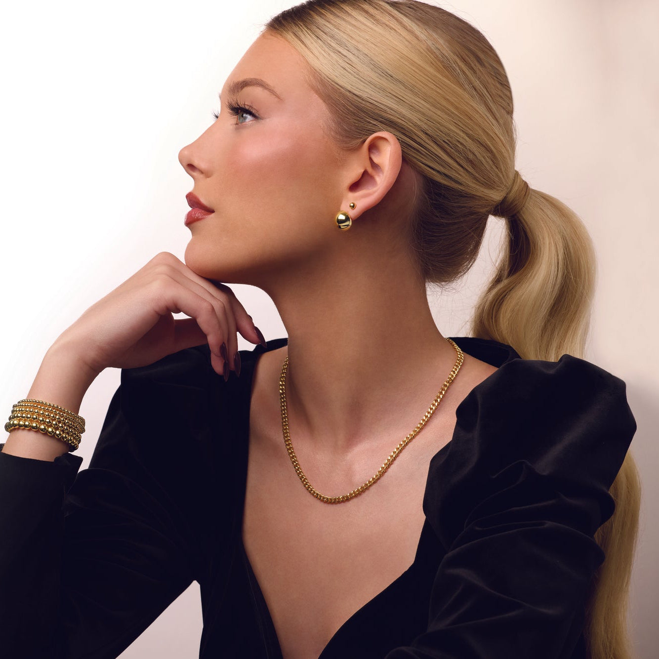 Woman wearing gold -filled curb chain necklace against a white background