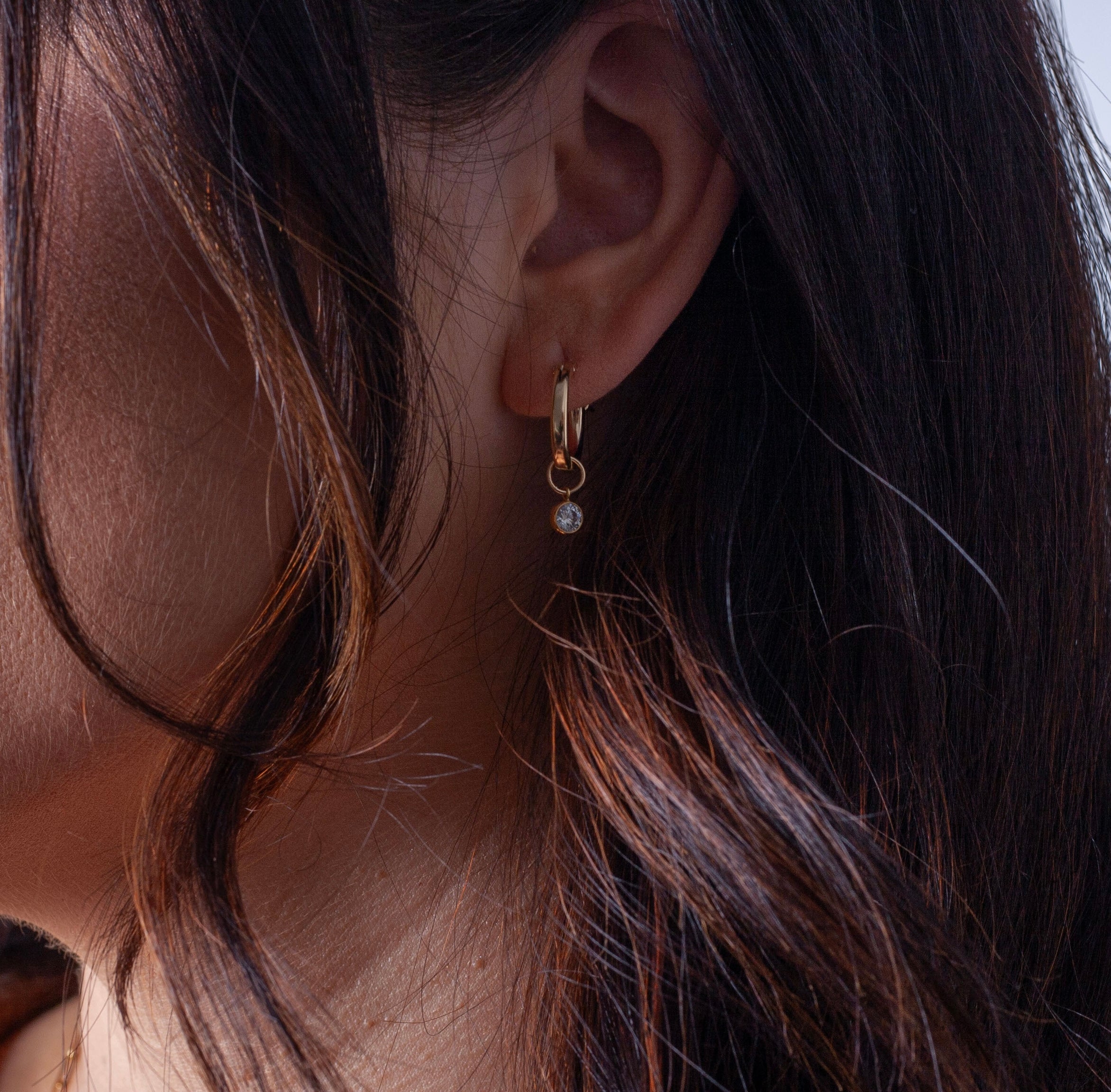 model wearing charmed gold filled hoops