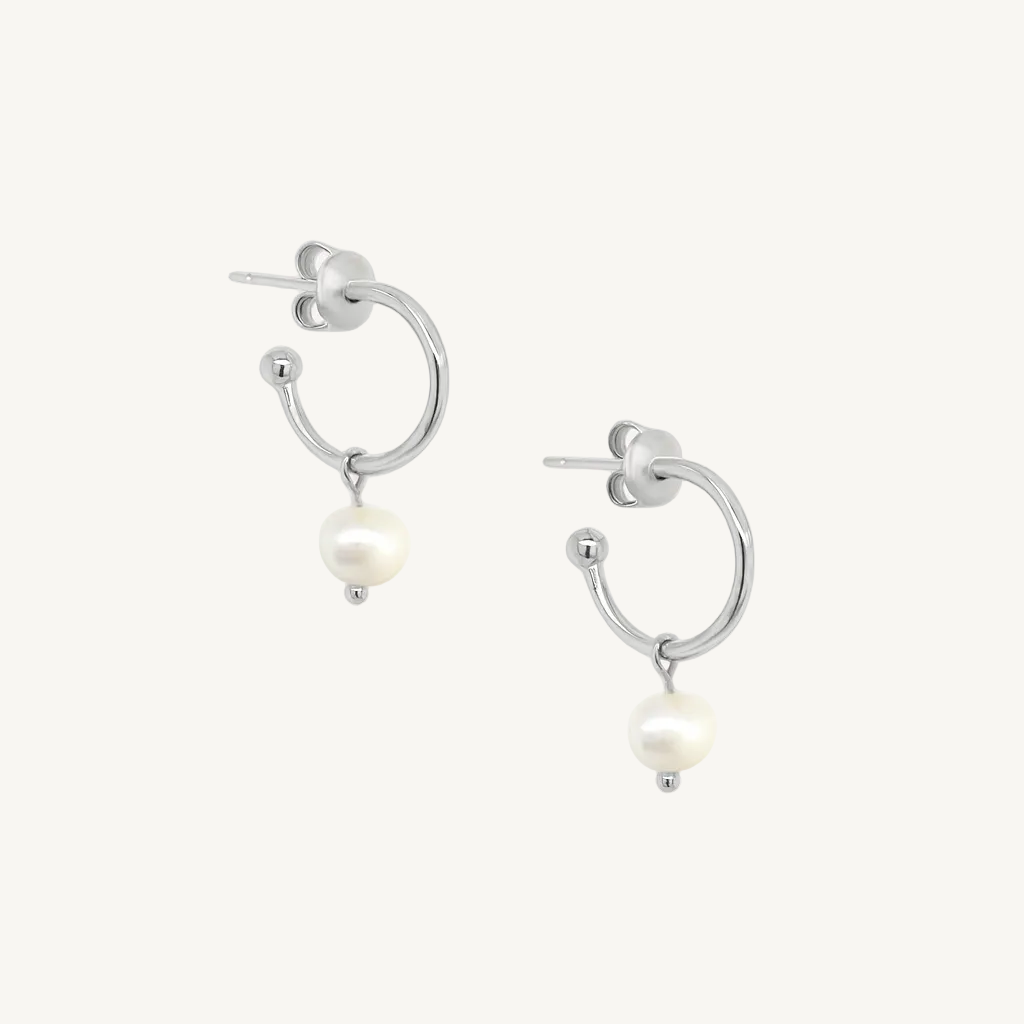Silver hoop earrings with pearl drops on a white background