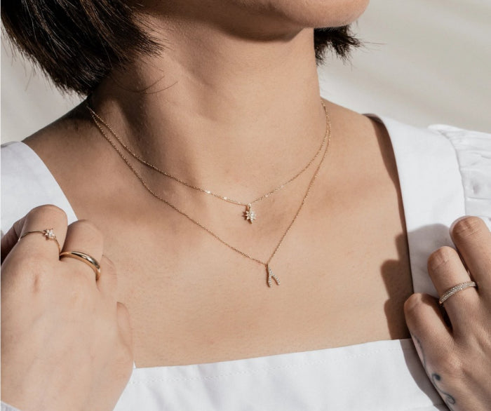 Person wearing a delicate wishbone necklace 
