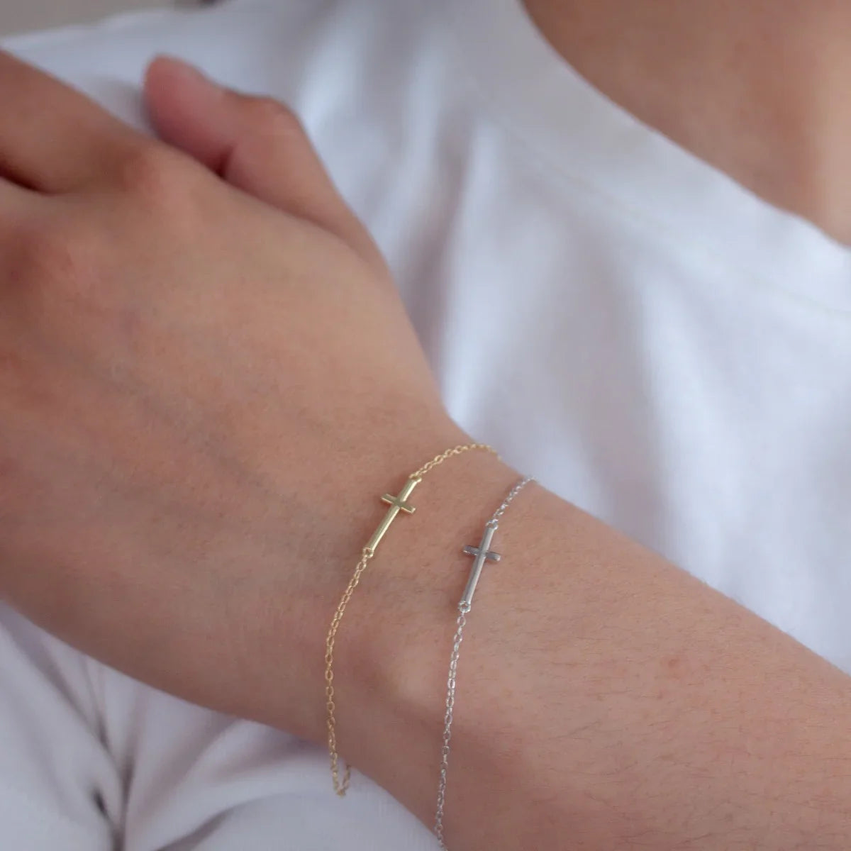 sterling silver and gold vermeil cross bracelets on wrist