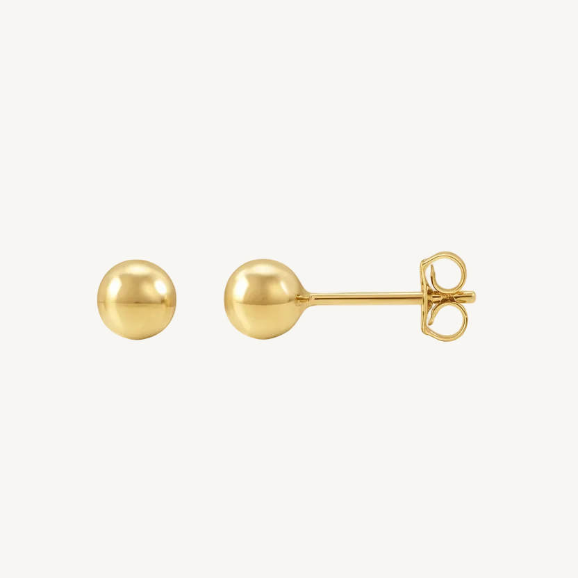 Gold ball earrings on a white background