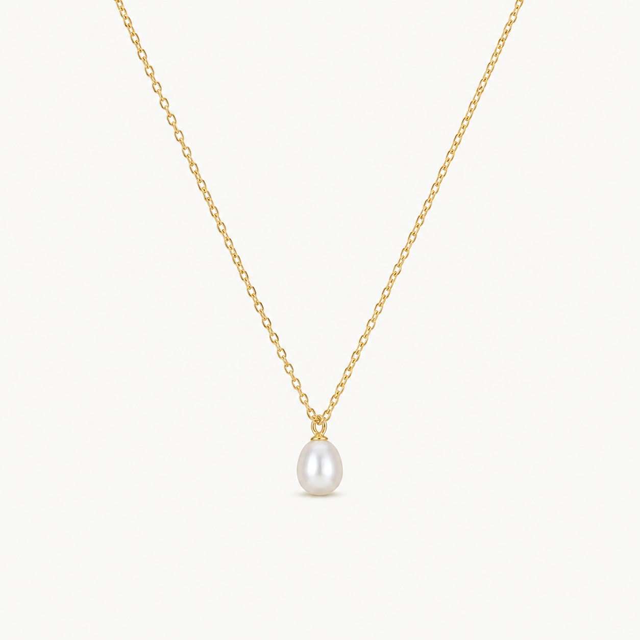 Gold necklace with a single pearl pendant on a white background