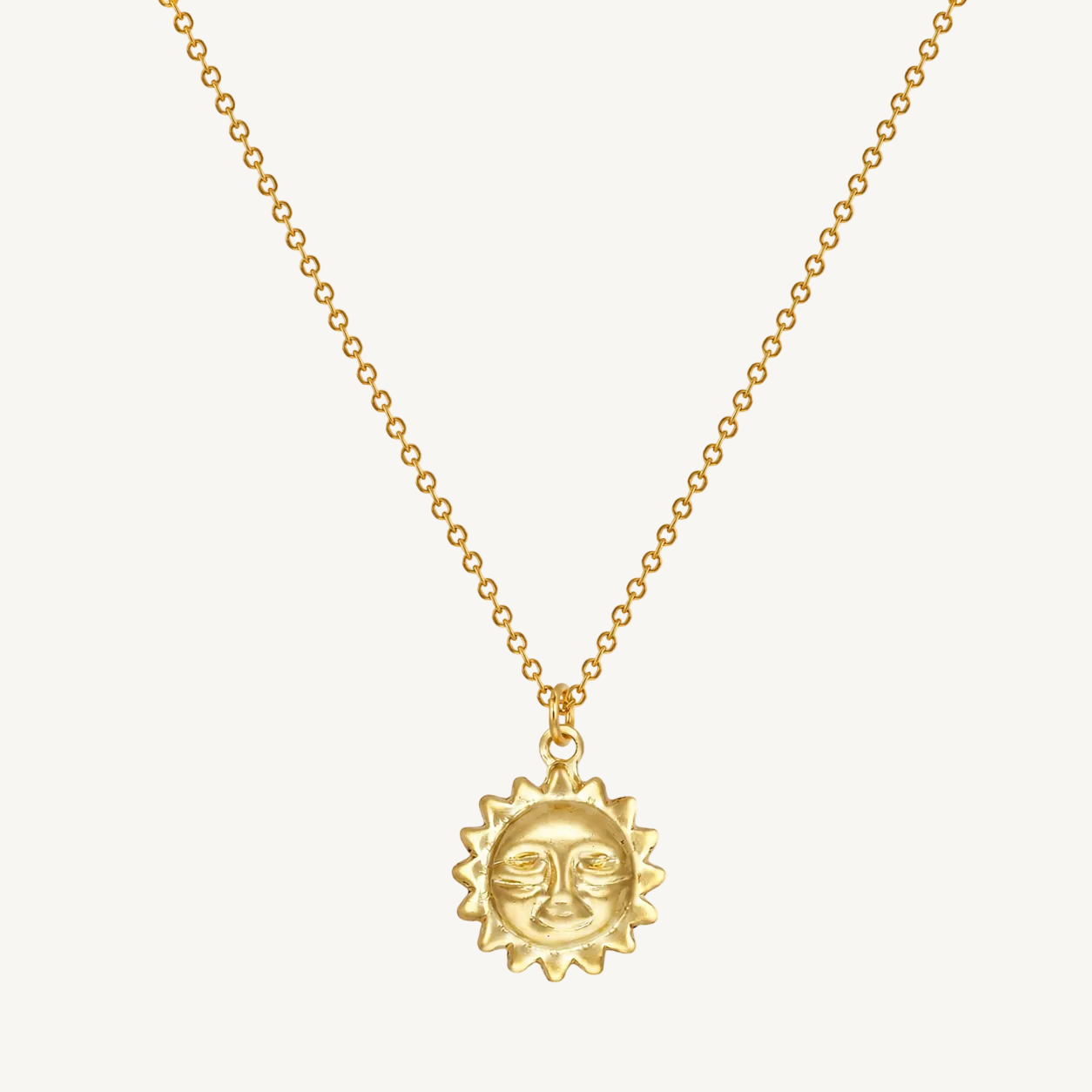 Gold necklace with a sun-shaped pendant on a white background