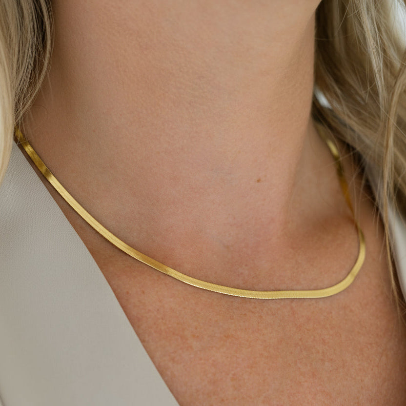 gold herringbone necklace on model