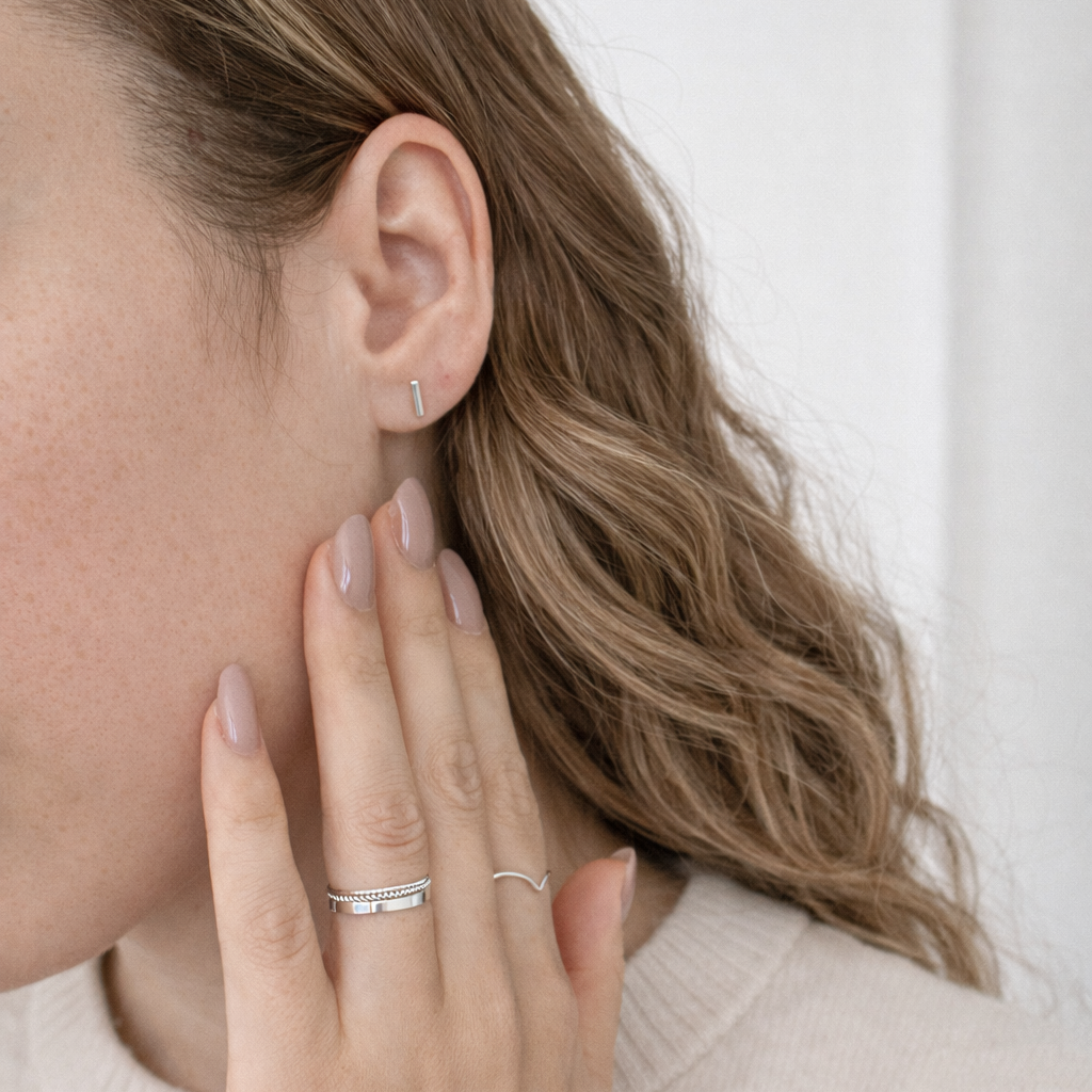 model wearing silver bar studs and silver stacking rings