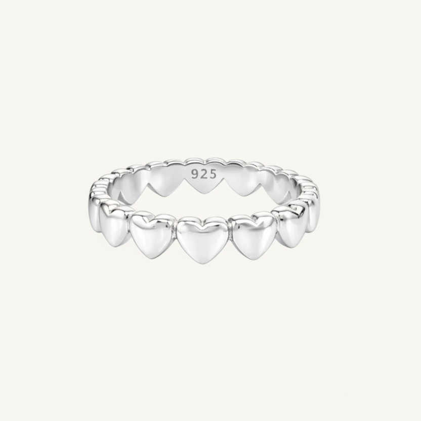 Silver ring with heart designs on a white background