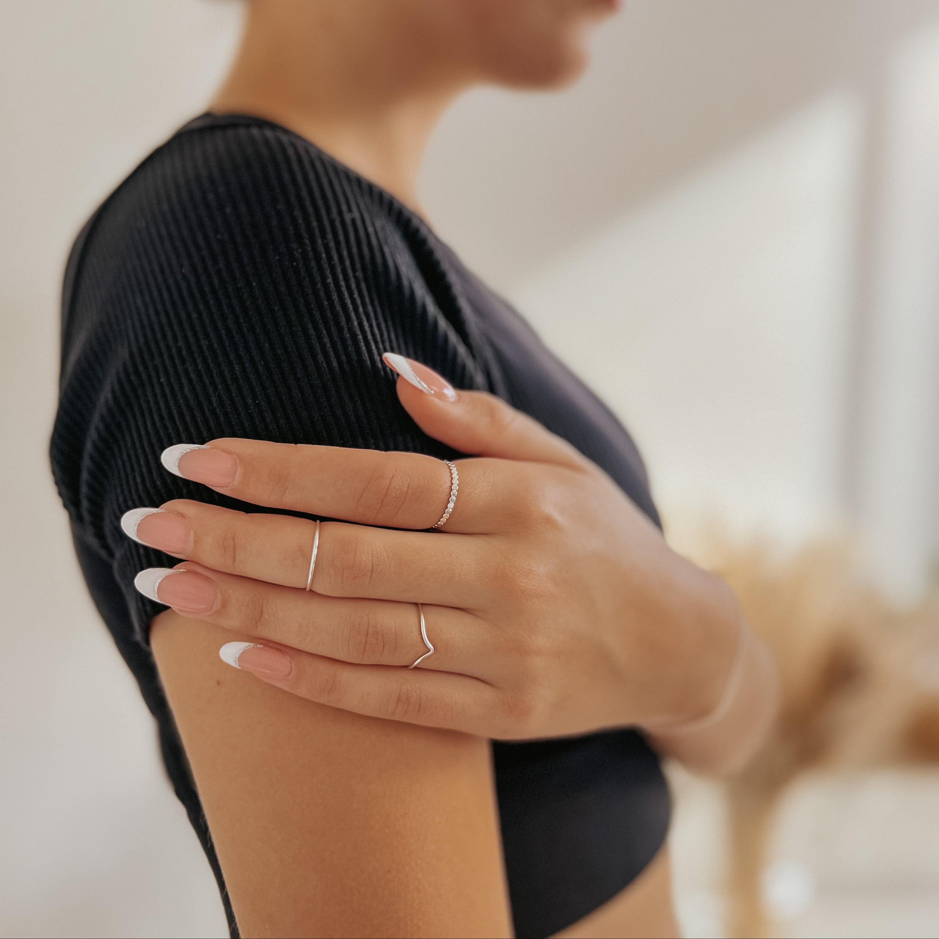 Woman wearing a black top with sterling silver stacking rings