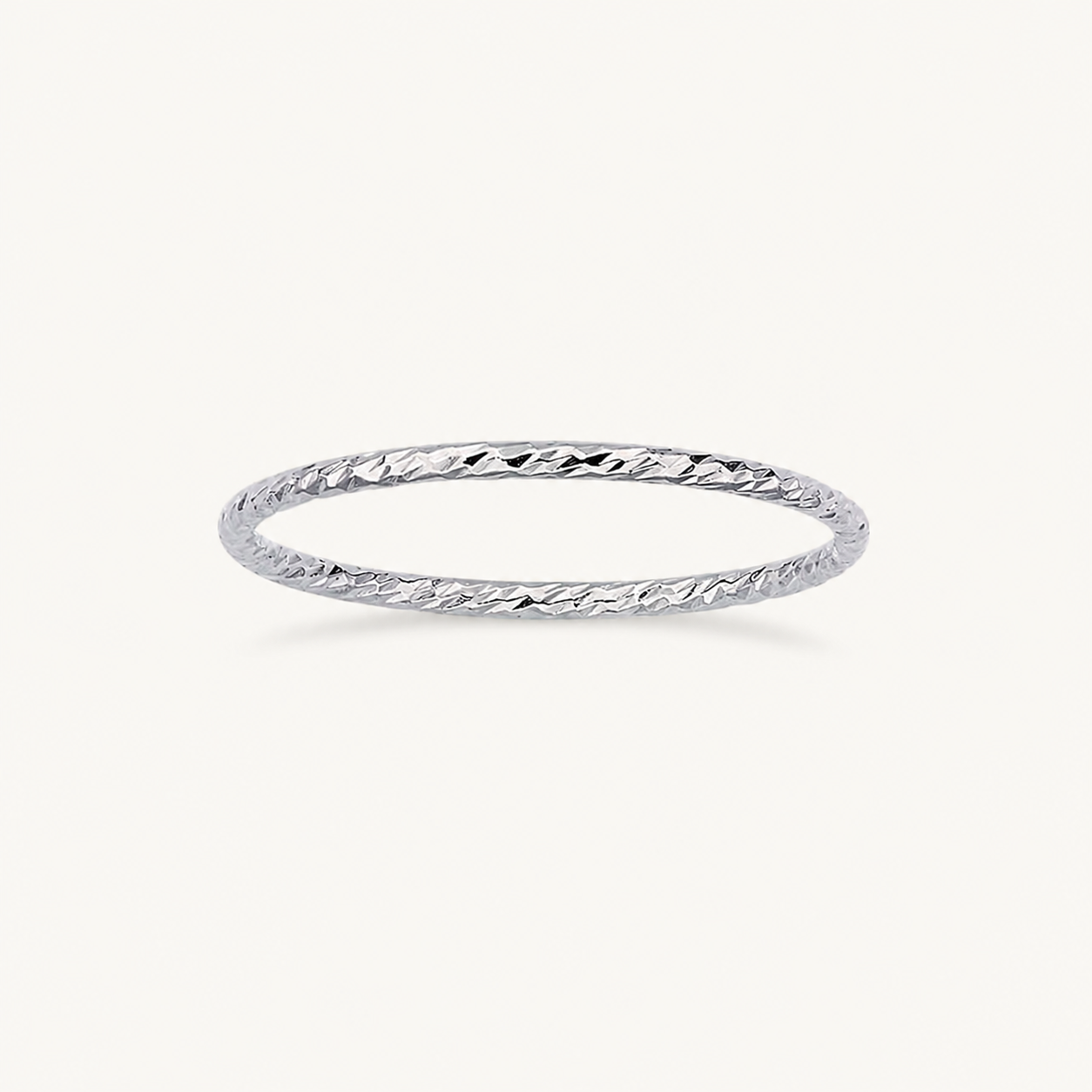 Silver ring with a textured band on a white background